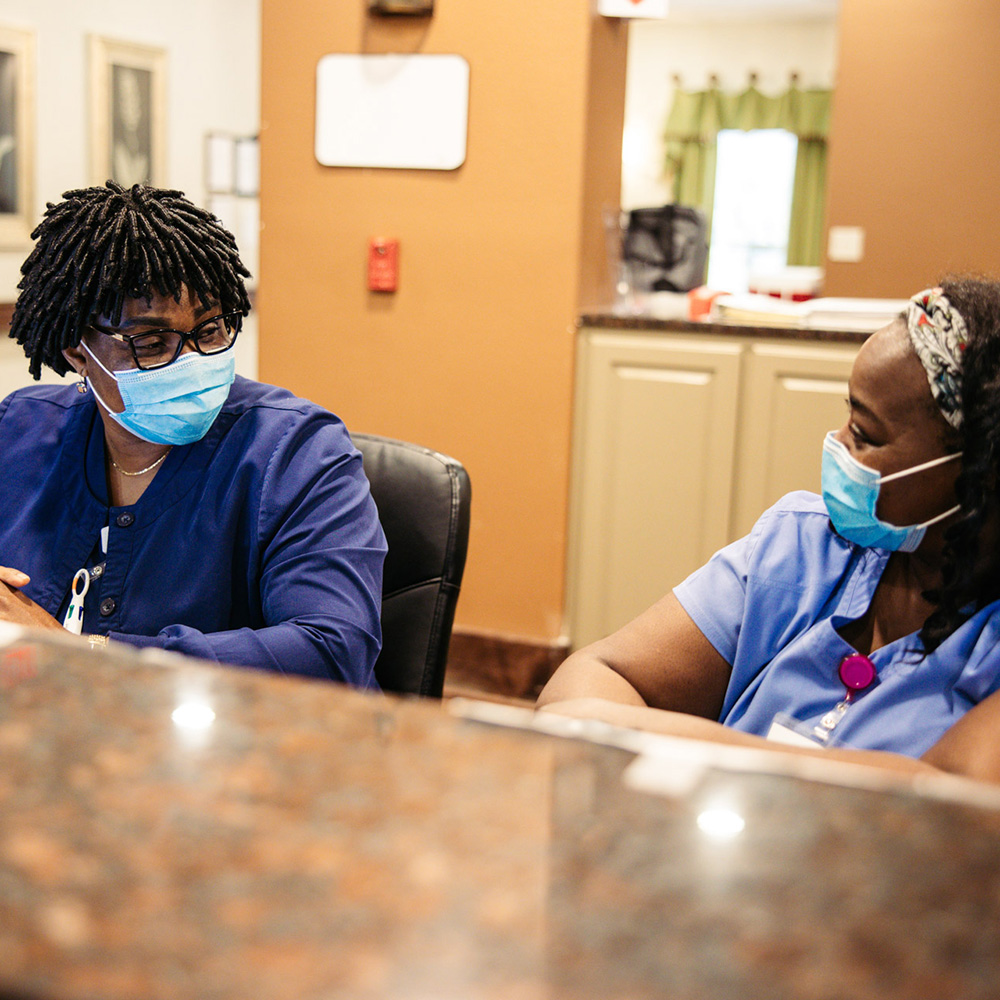 Two staff members conversing at a reception desk