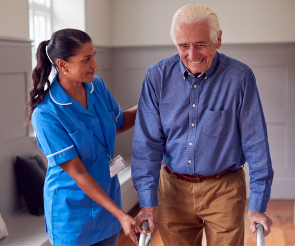 Nurse assisting elderly man with a walker