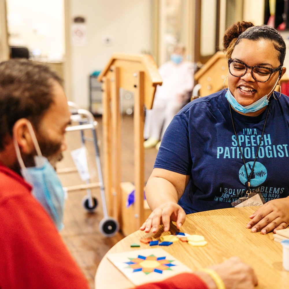 Therapist interacting with a resident at a table