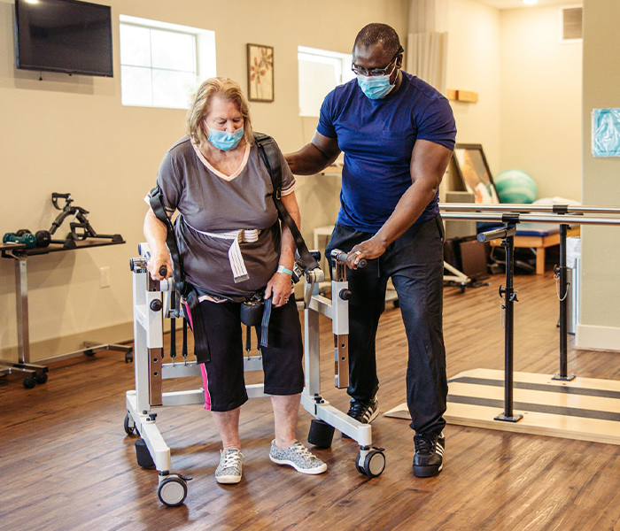 Staff assisting resident with rehabilitation