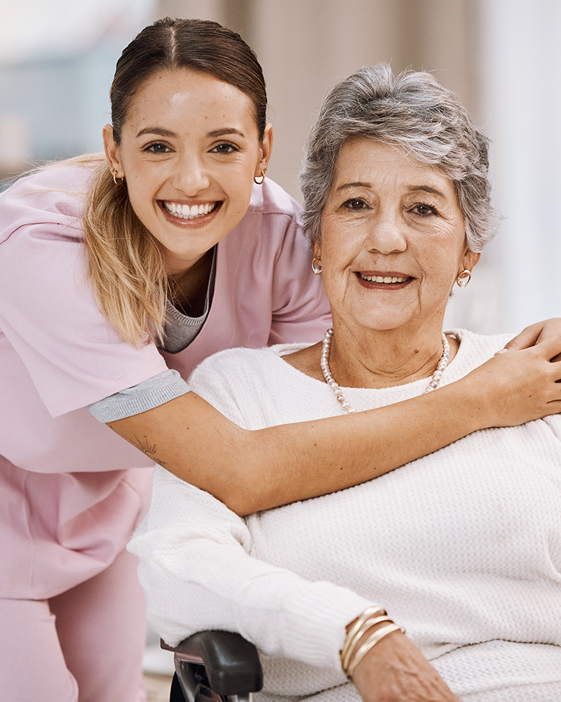 Healthcare worker smiling with an elderly resident.