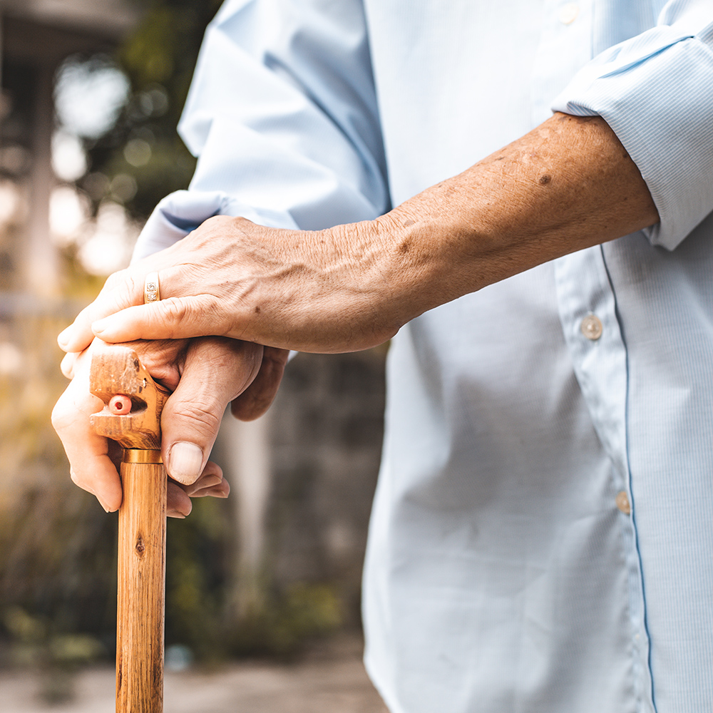 Close-up of a hand on a wooden cane