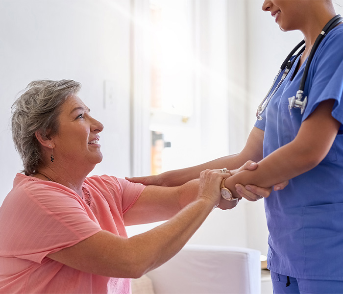 Caregiver assisting a resident in an indoor setting.