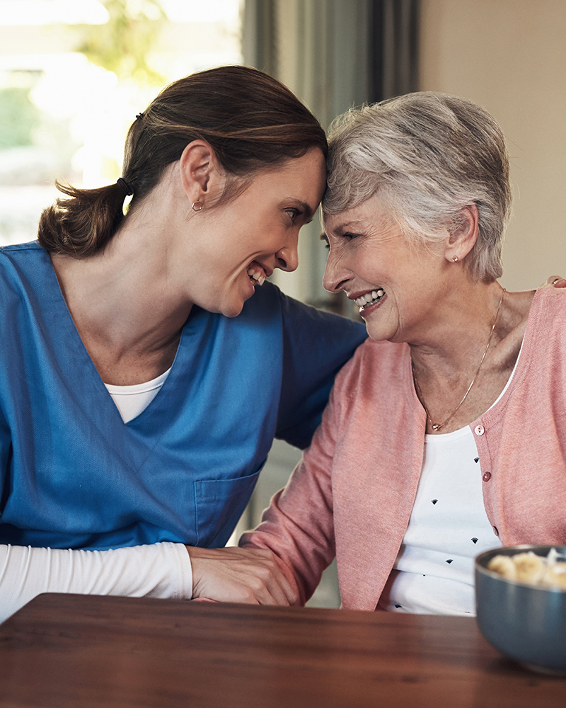 A caregiver and a resident sharing a joyful moment