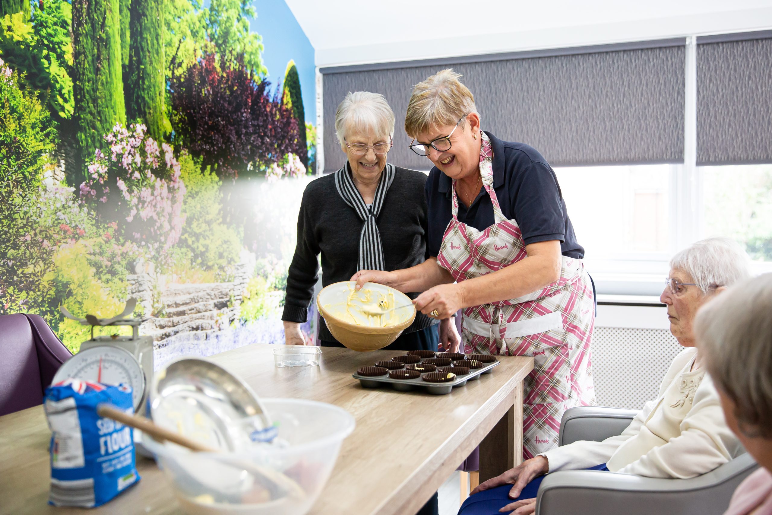 Residents baking muffins together in a common area.