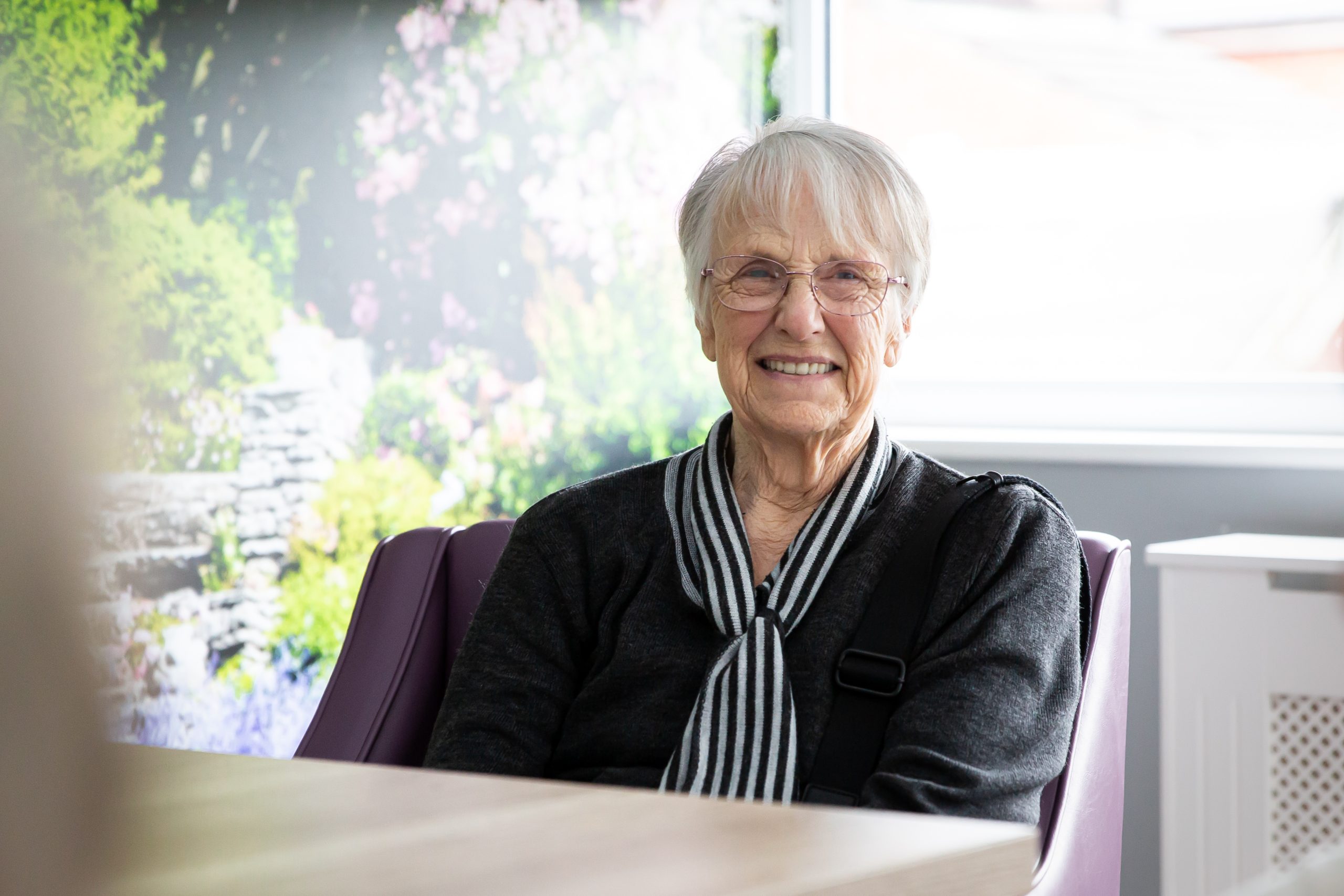 Smiling resident in a bright interior space.