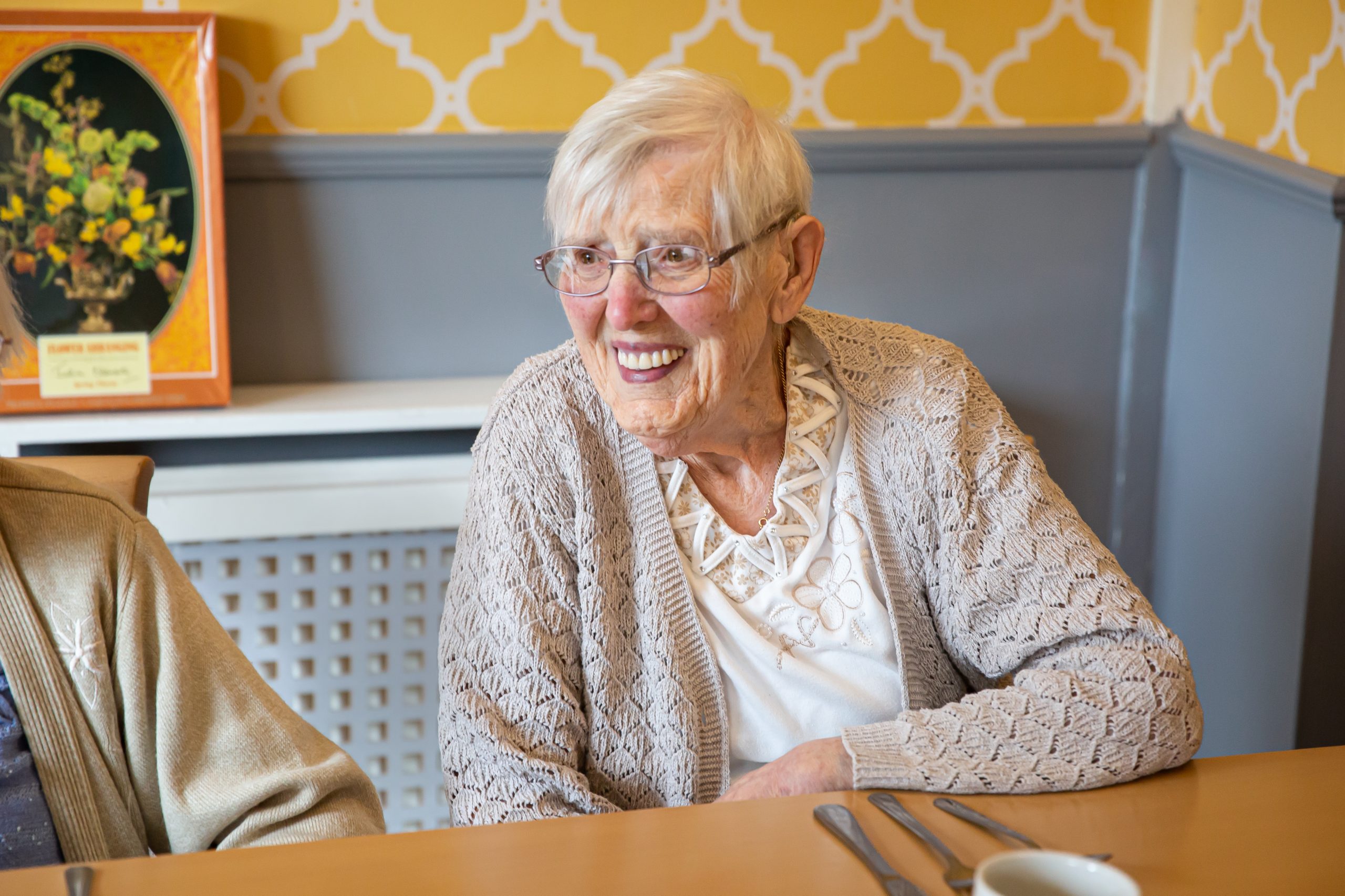 Smiling elderly woman in dining area
