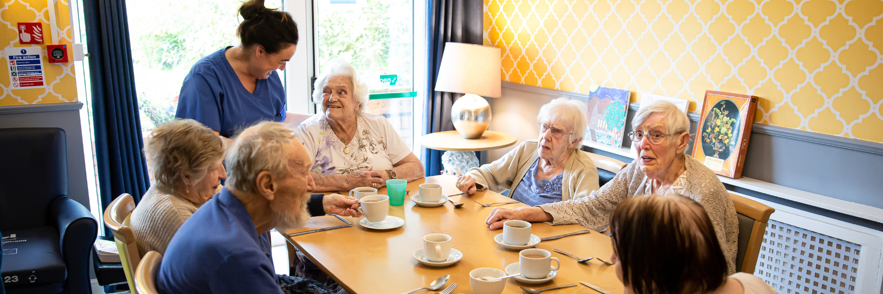Residents enjoying tea in a cheerful dining area.