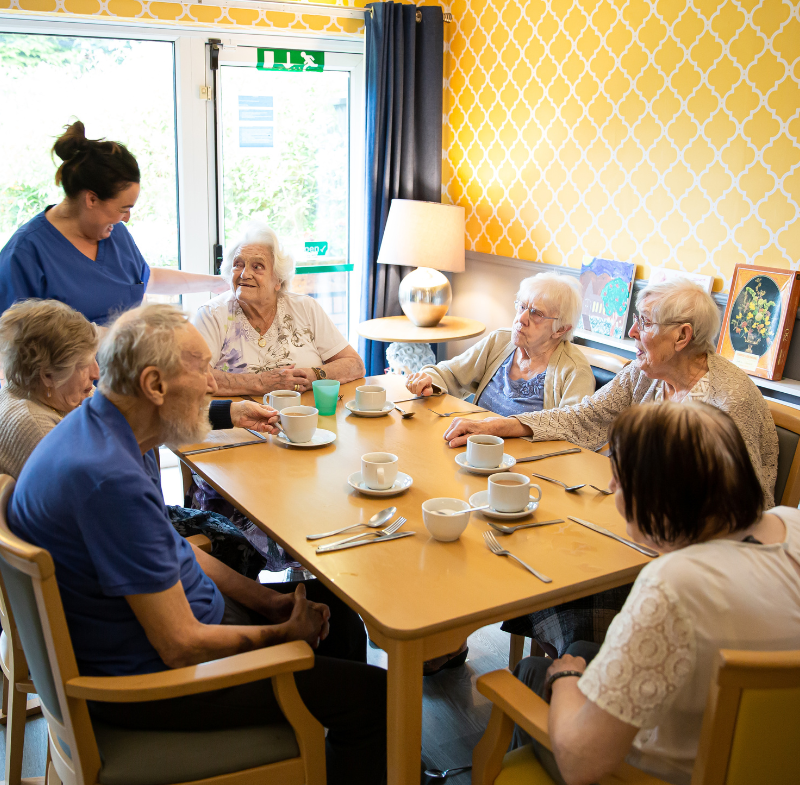 Residents enjoying tea in a communal dining area.