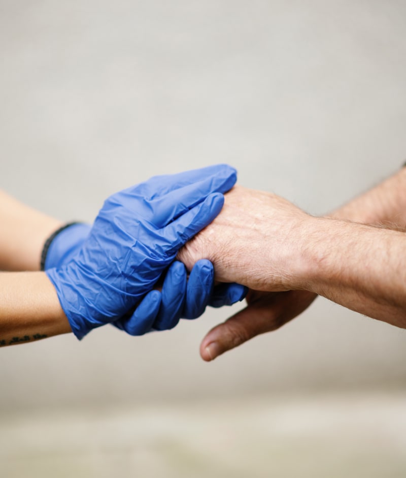 Close-up of two hands, one gloved and one bare.