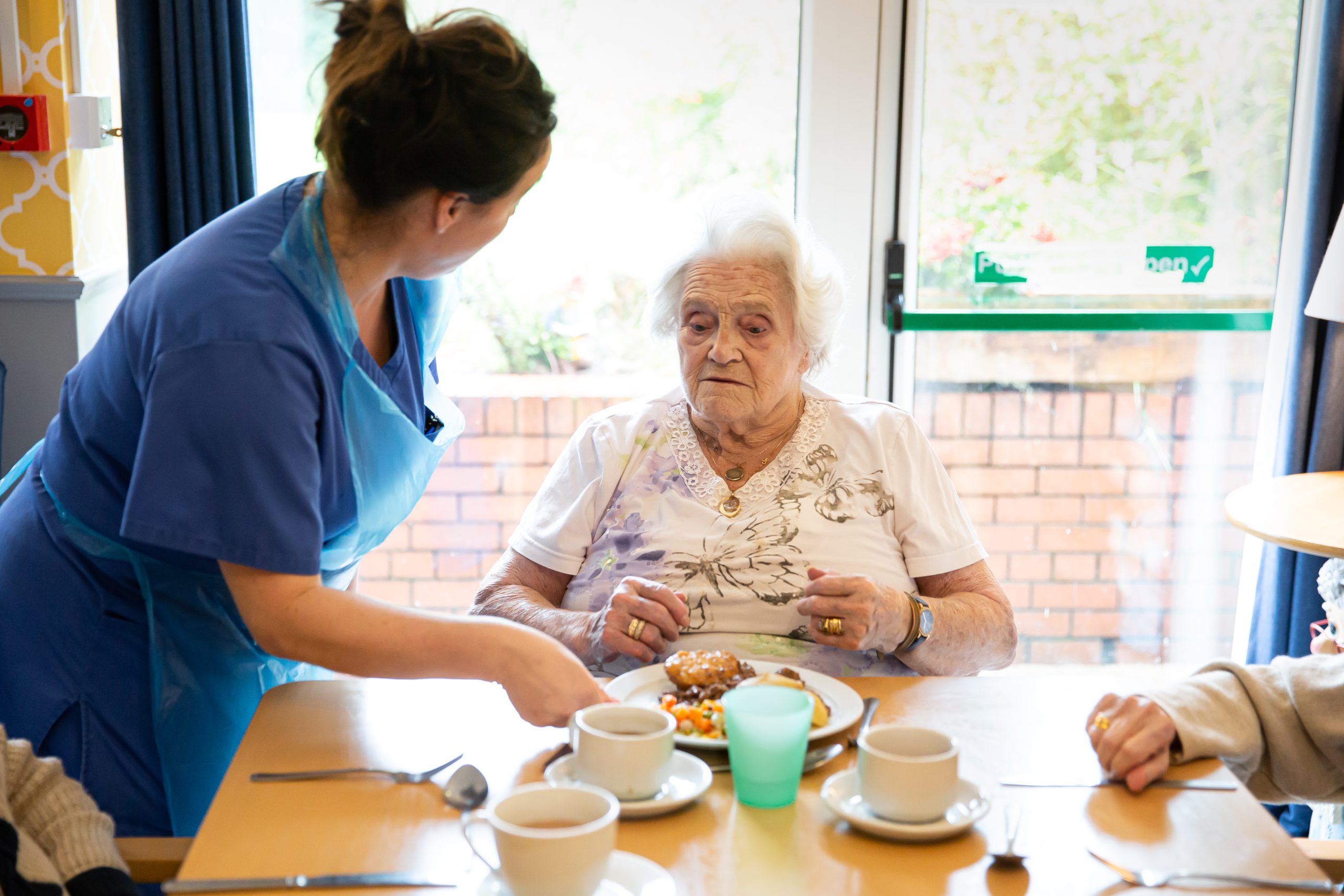 Care staff serving food to a resident