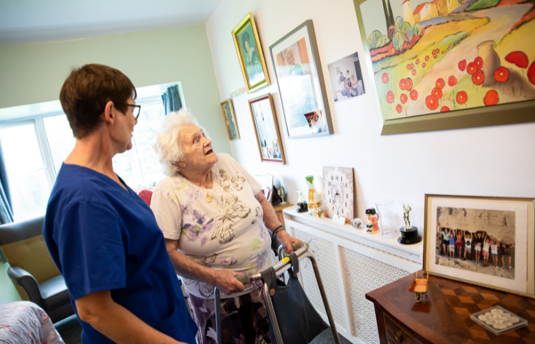 Staff member assisting resident with artwork