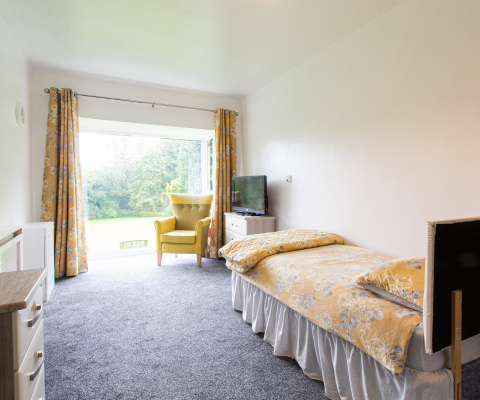 Cozy resident room with a view of greenery.