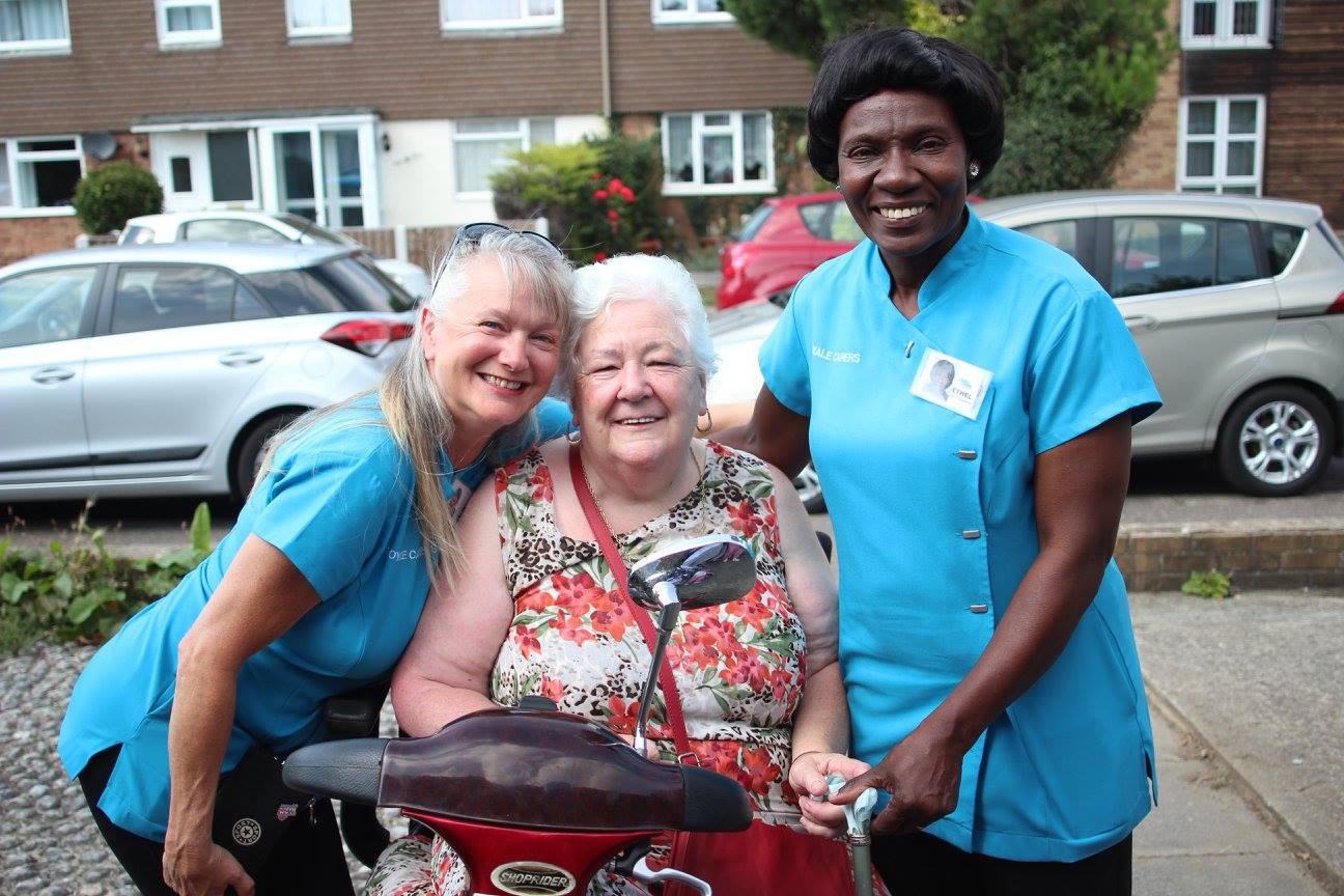 Resident enjoying time with caring staff outside.