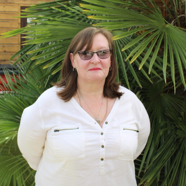 Woman standing in front of palm plants