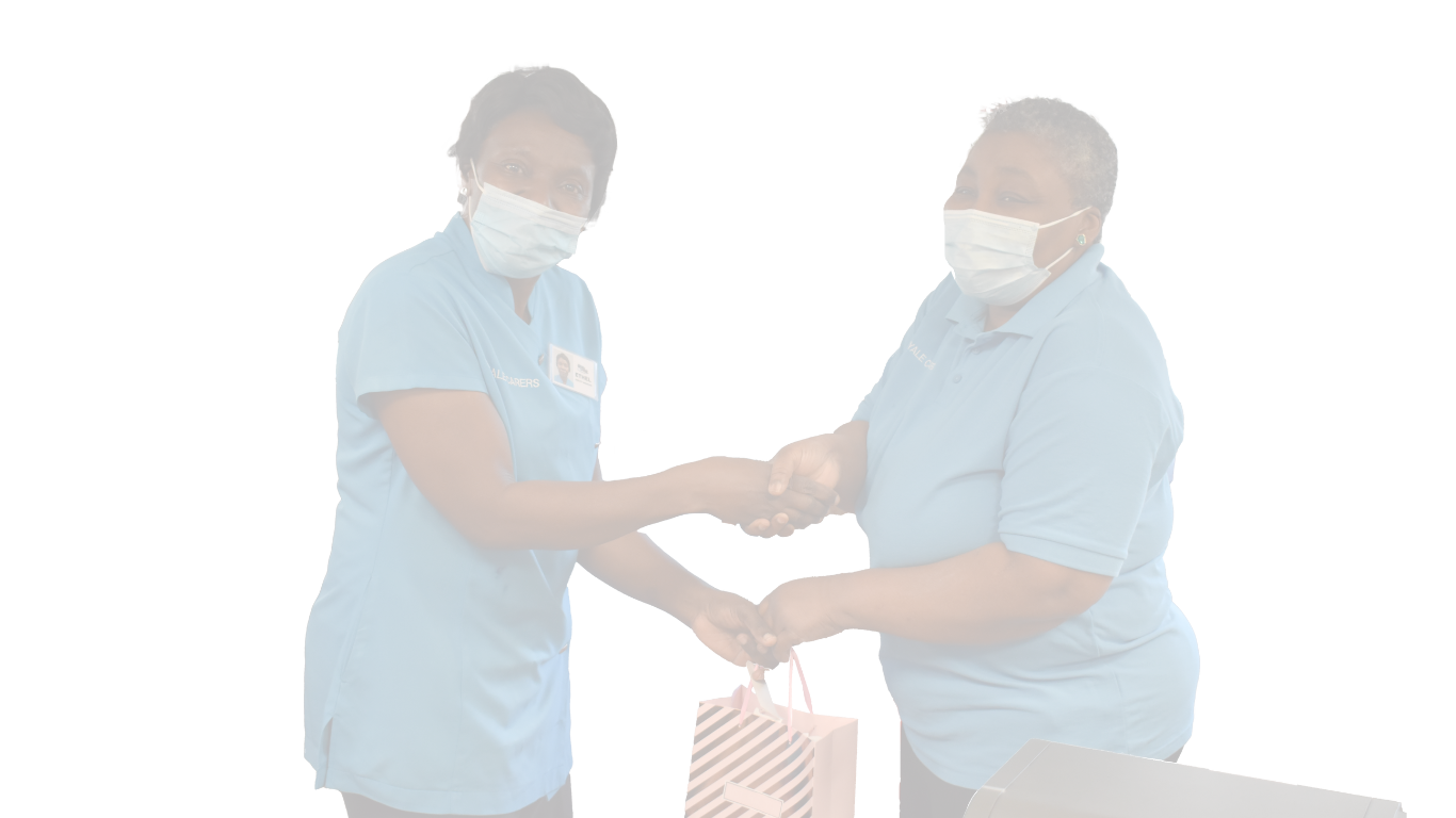 Staff members exchanging a gift in the facility