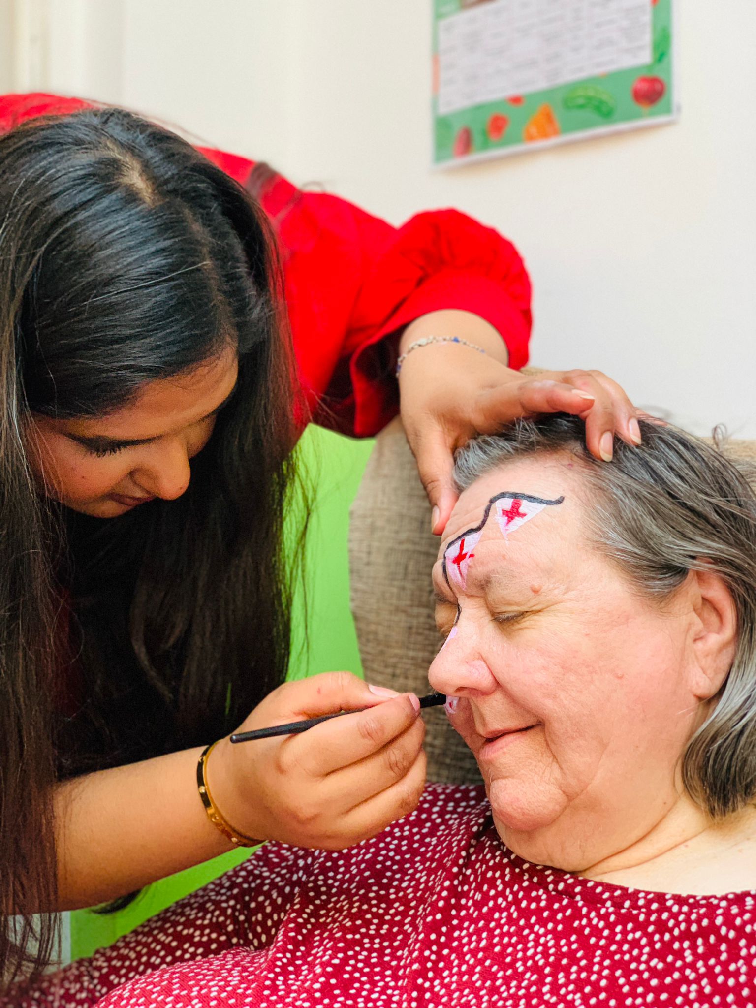 Staff member painting a resident's face