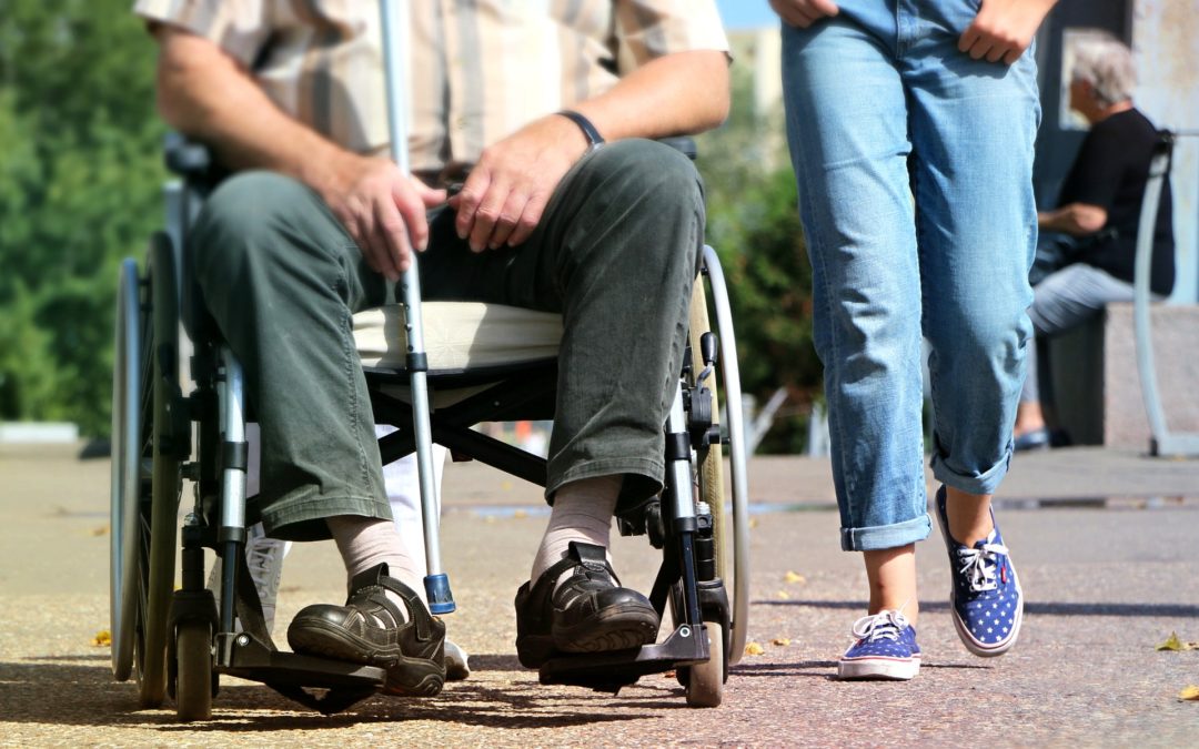 Senior resident in a wheelchair enjoying a walk.