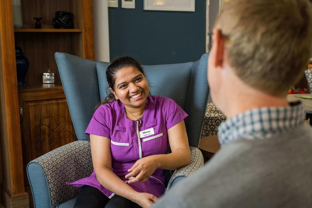 Staff member interacting with a resident in a common area.
