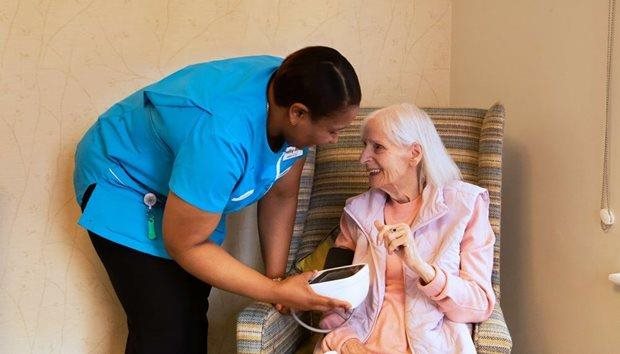 Staff member assisting resident with health monitor