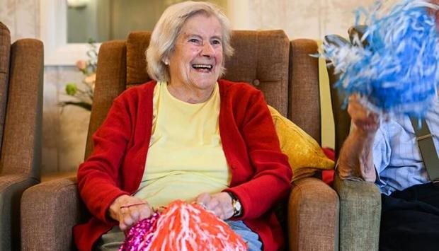 Elderly woman enjoying an activity in a cozy lounge