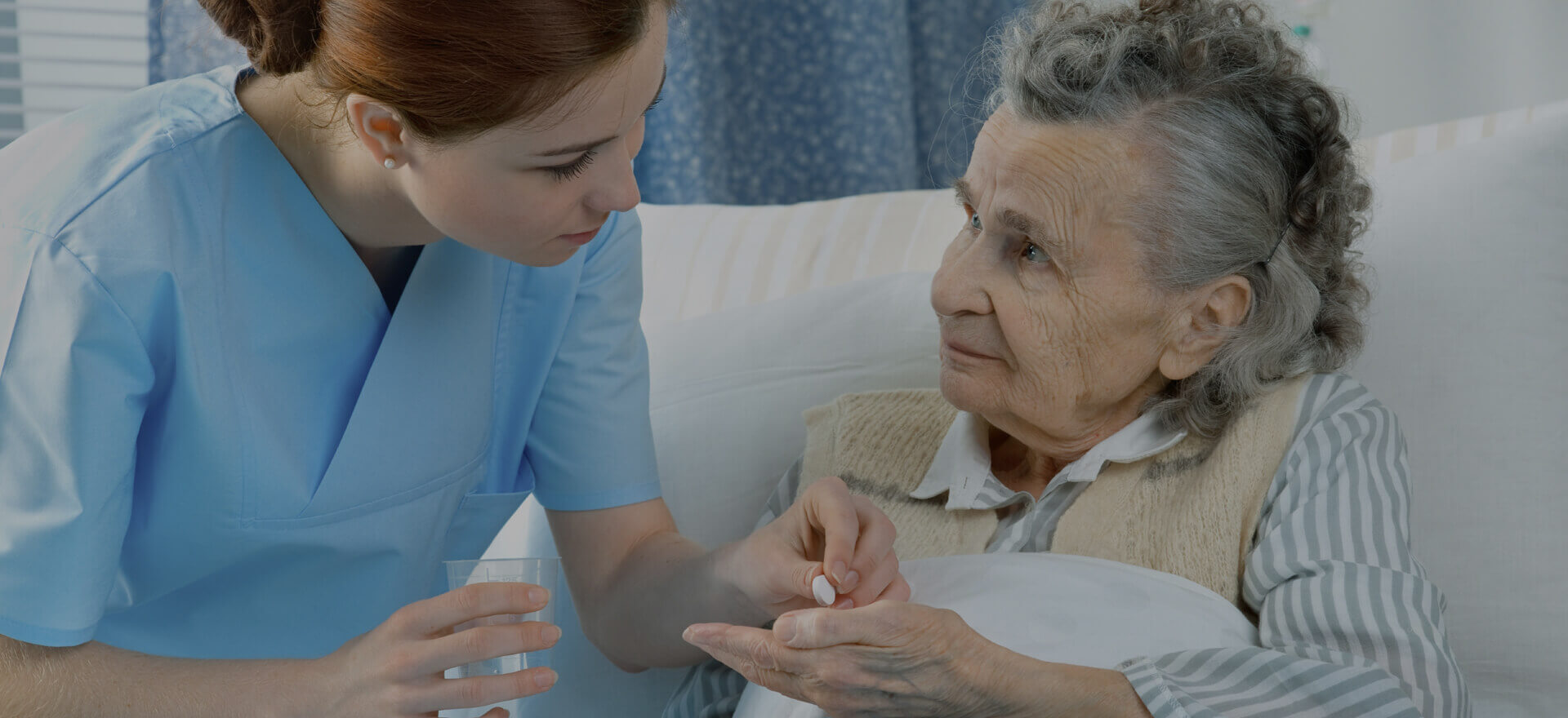 Nurse assisting an elderly patient with medication.