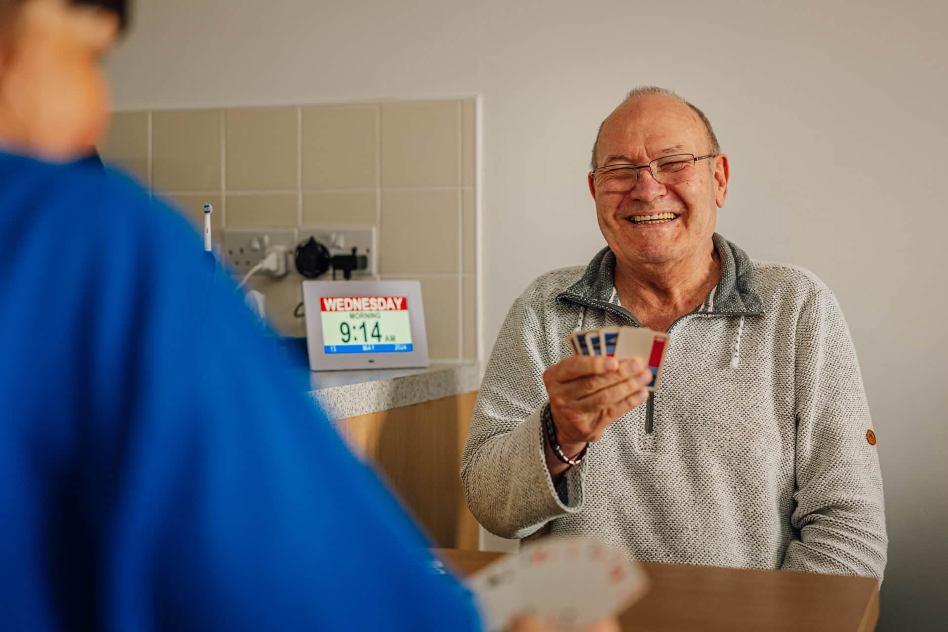 Senior man enjoying a card game and smiling.