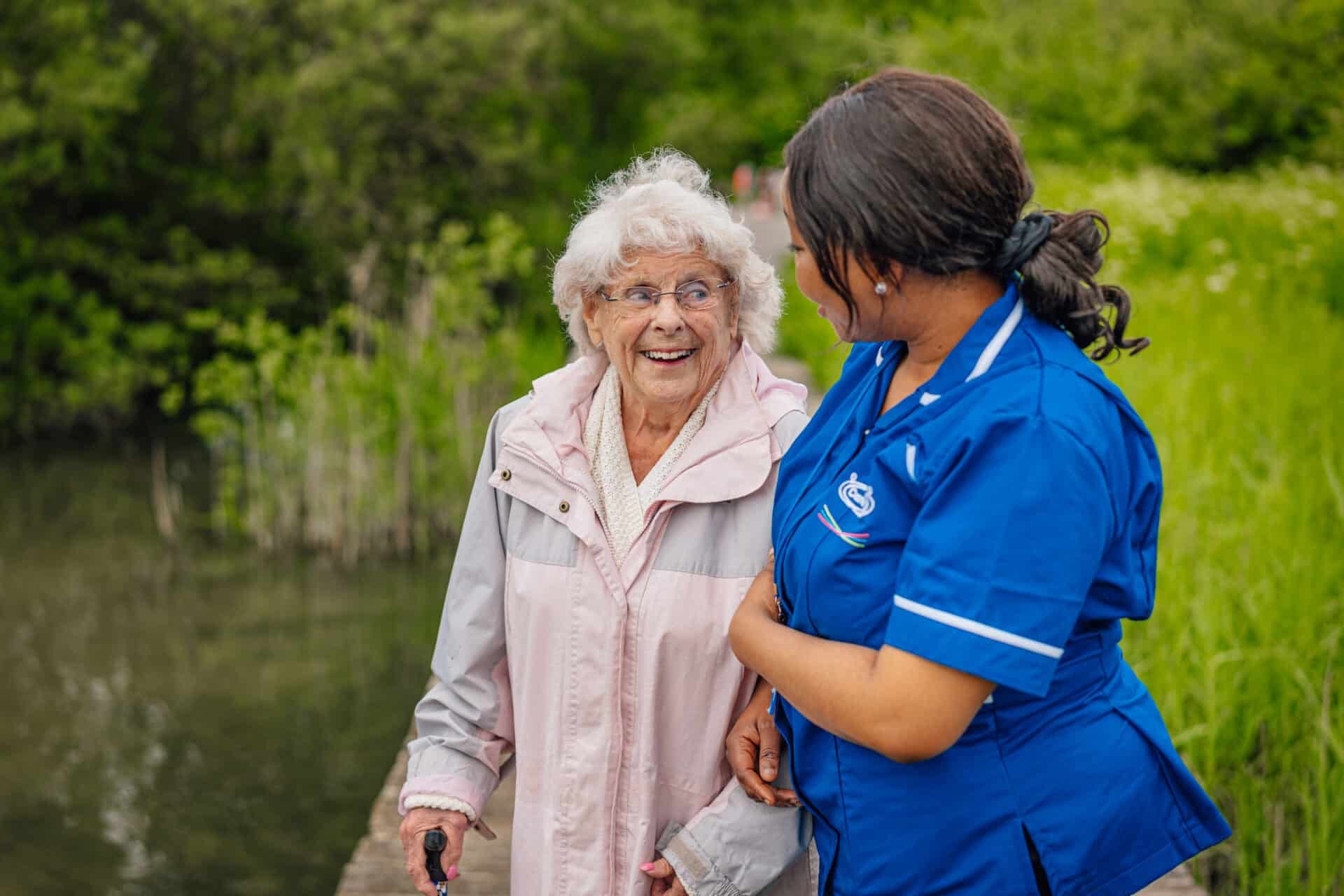 Care staff and resident enjoying an outdoor stroll.