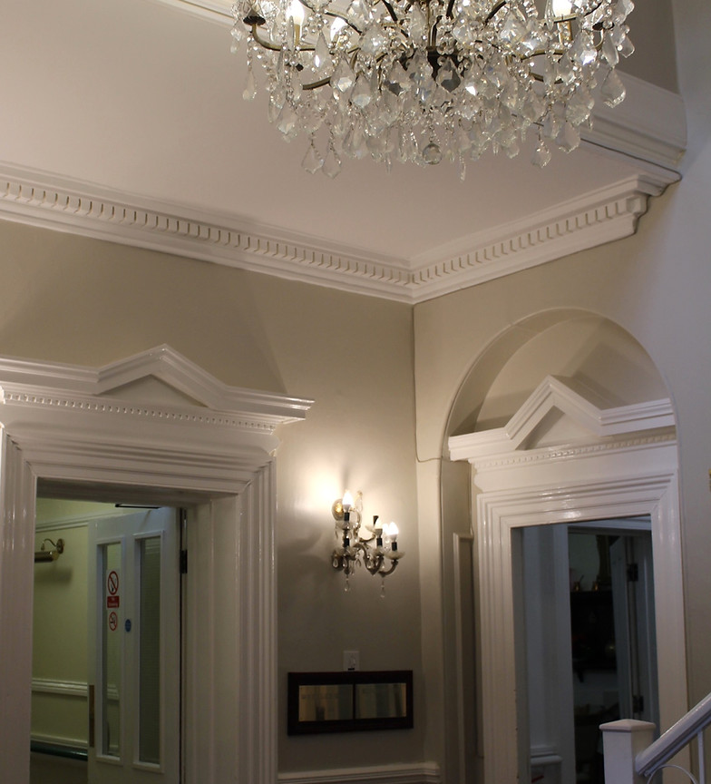 Elegant lobby area with chandelier and lights.