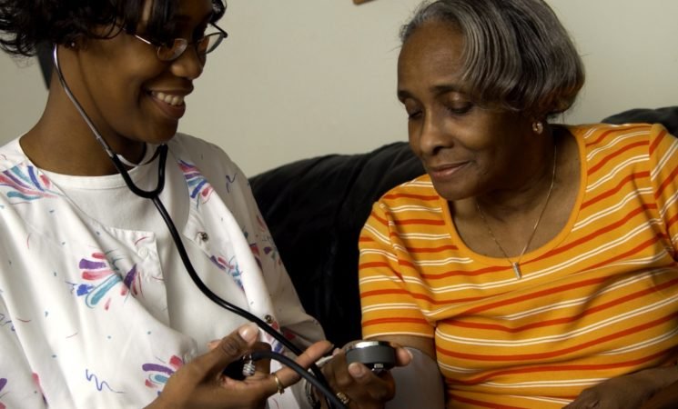 Caregiver checking blood pressure of a resident.