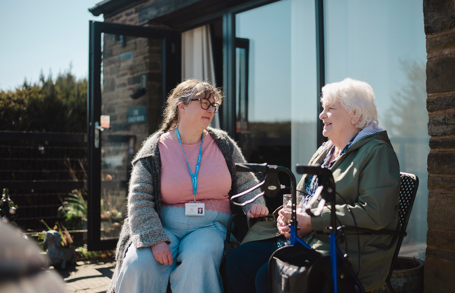 Two women engaging outside in a relaxed setting.
