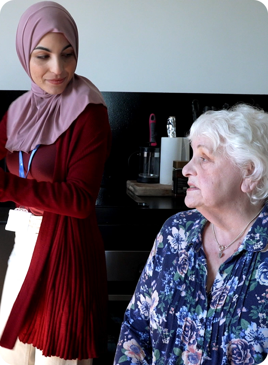 Caregiver interacting with a resident in a kitchen.