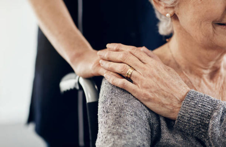 Close-up of a caregiver's hand on a resident's shoulder