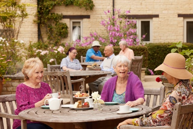 Residents enjoying tea outdoors in a communal area