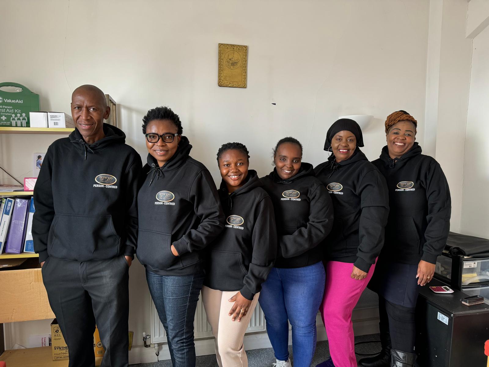 A group of staff members in hoodies.