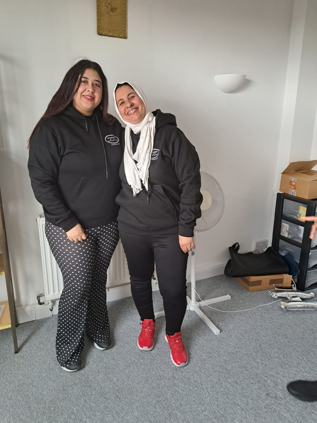 Two staff members smiling in a common area