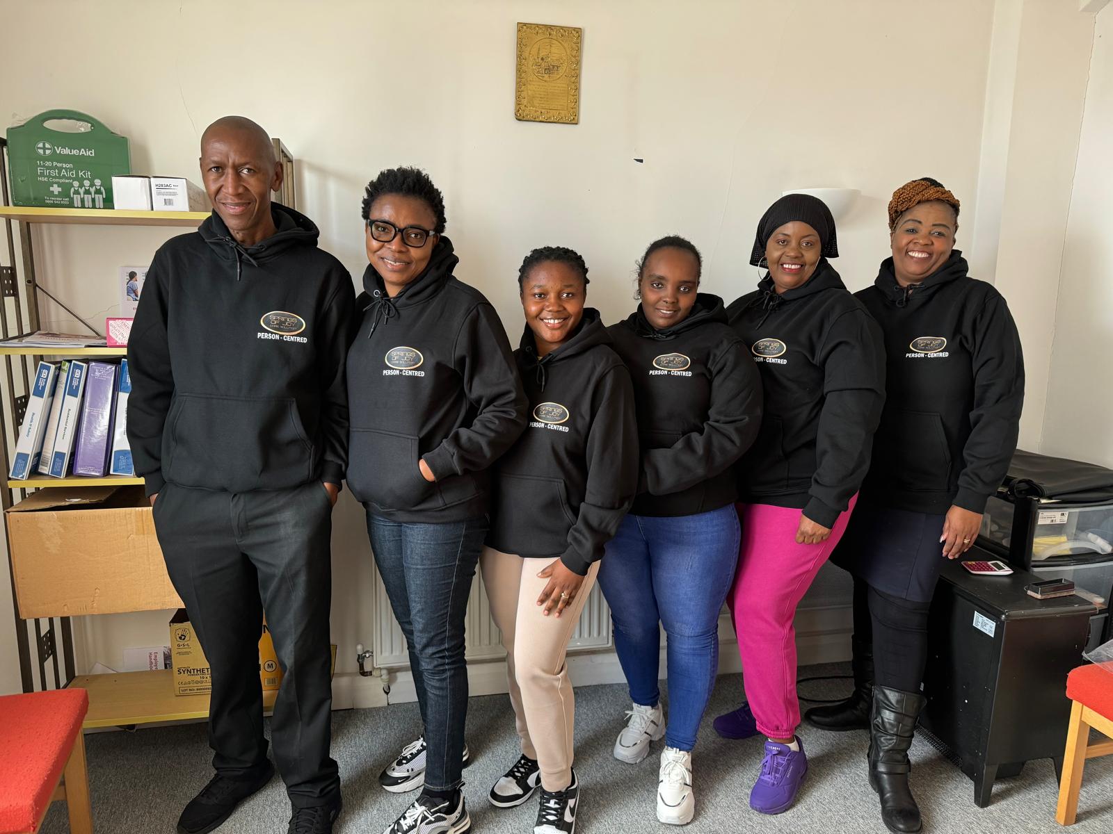 Staff members wearing branded hoodies together.