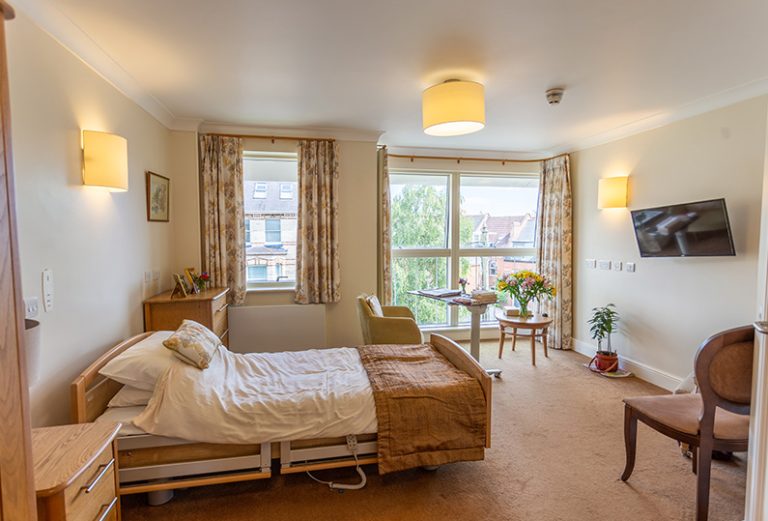 Cozy resident room with bed and seating area.