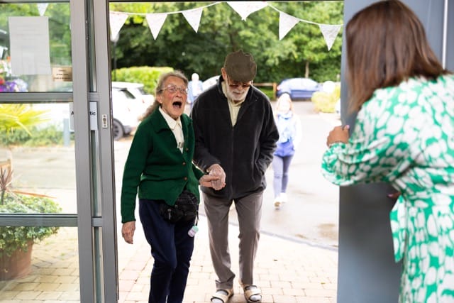 Residents joyfully entering the facility together.