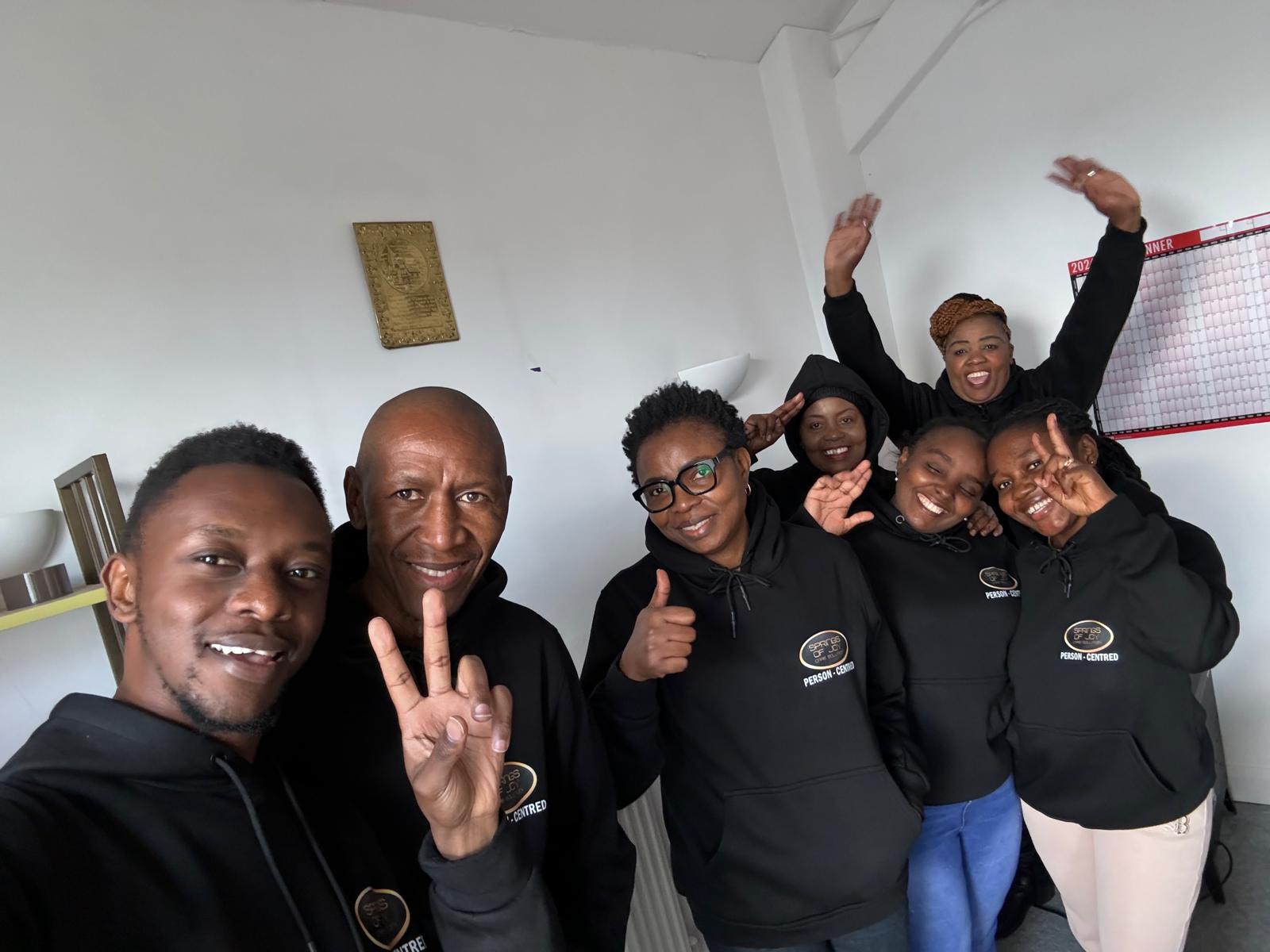 Group of smiling staff members in hoodies