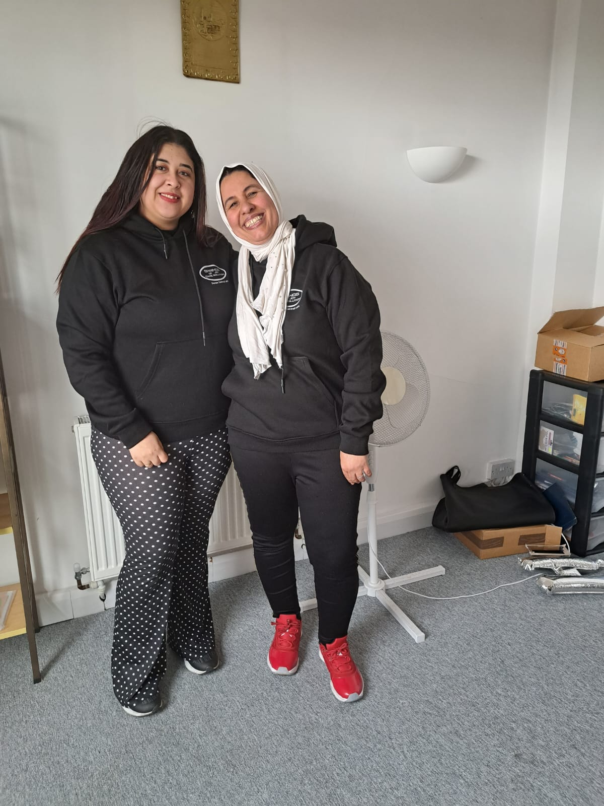 Two staff members posing in a casual setting.