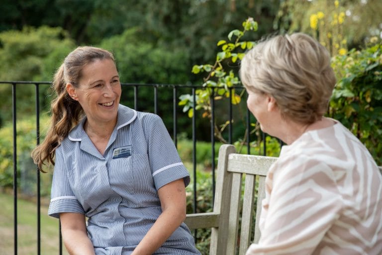 Staff member conversing with a resident outdoors