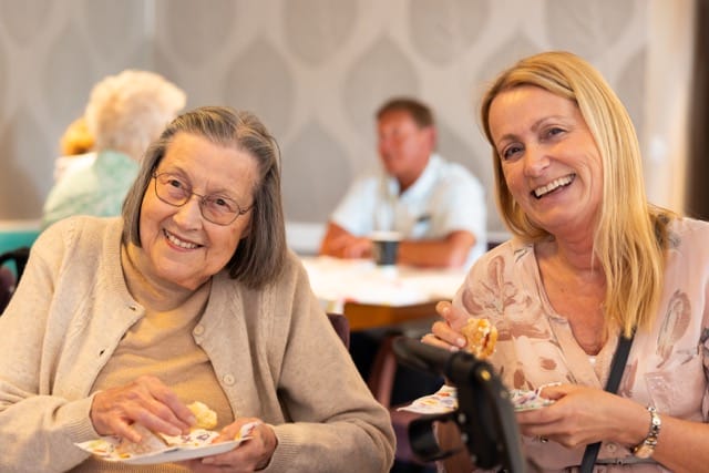 Residents enjoying snacks at a communal table.