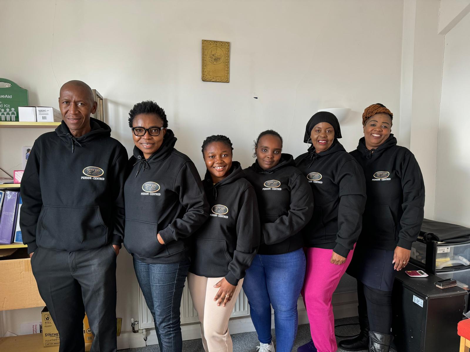 Staff members in matching hoodies, smiling together