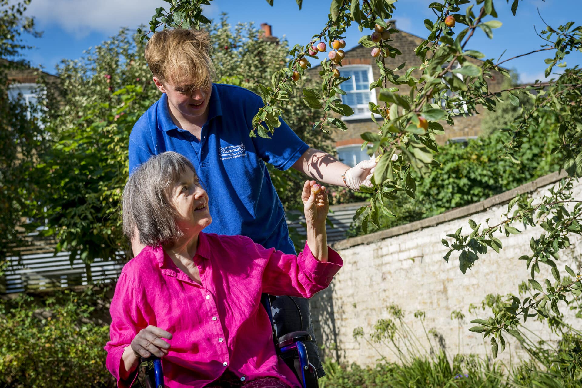 Resident enjoying nature with staff assistance.