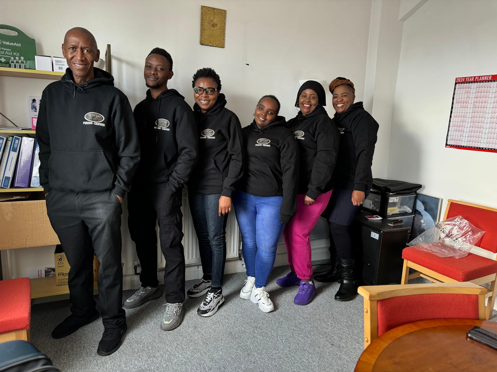 Staff members in matching hoodies in a common area.