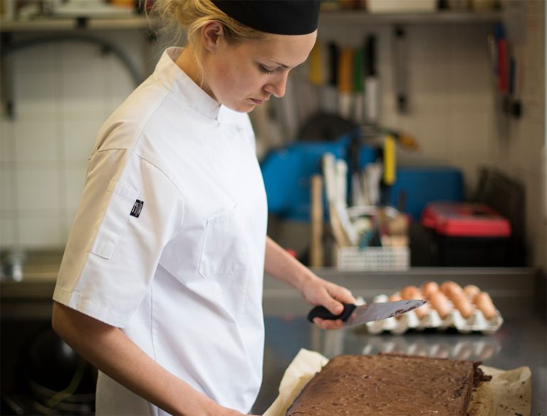 Staff member preparing food in the kitchen.