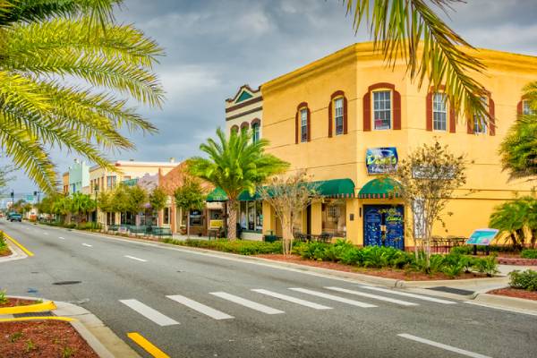 Colorful building exterior along a palm-lined street