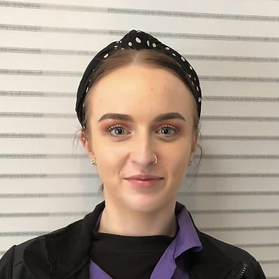 Staff member smiling, wearing a polka dot headband.