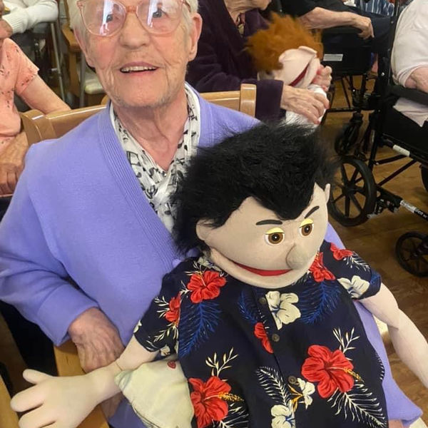 Senior resident with puppet during activity
